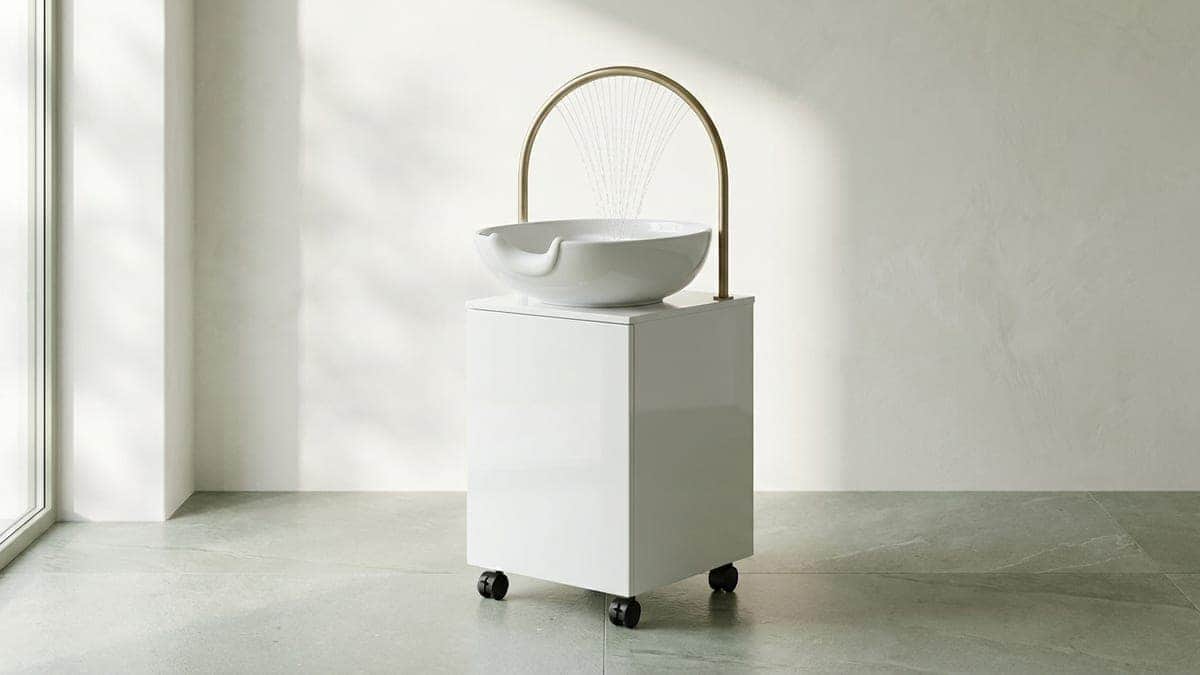 Bac head spa blanc sur roulettes, vasque ronde échancrée pour la nuque, arceau en laiton d'où tombe une pluie d'eau fine