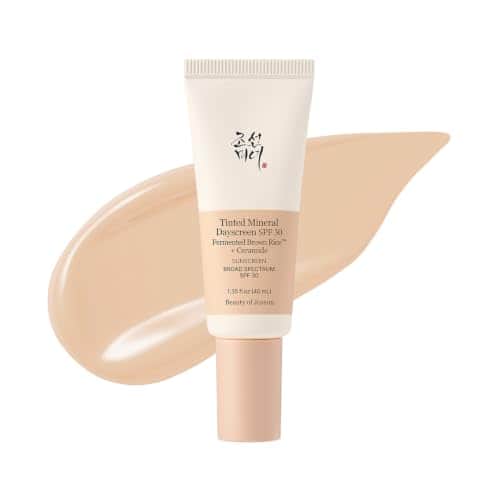 Tube crème et beige de la Beauty of Joseon Tinted Mineral Dayscreen SPF 30, 40 ml, devant une large trace de crème teintée beige