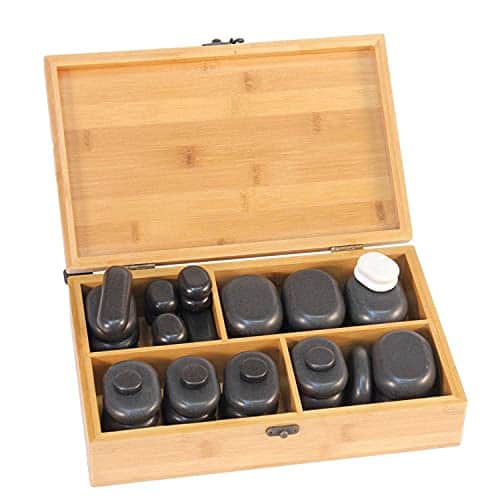 Coffret en bambou ouvert, à quatre compartiments remplis de pierres de basalte noires de plusieurs tailles et d'une pierre blanche