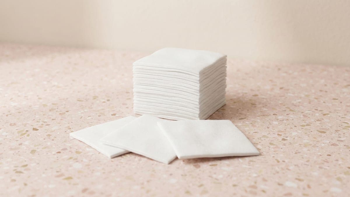 Pile de carrés de coton blancs, trois carrés étalés devant