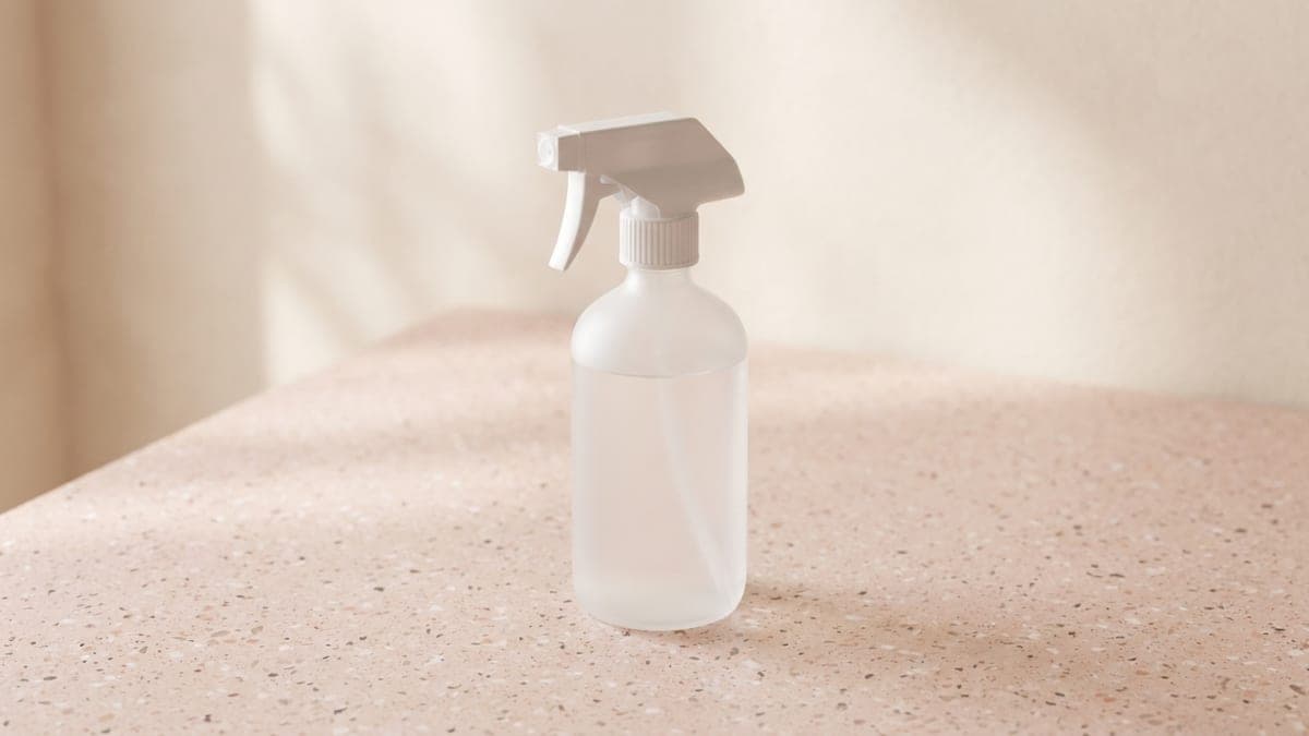 Flacon pulvérisateur blanc sans étiquette, rempli d'un liquide transparent