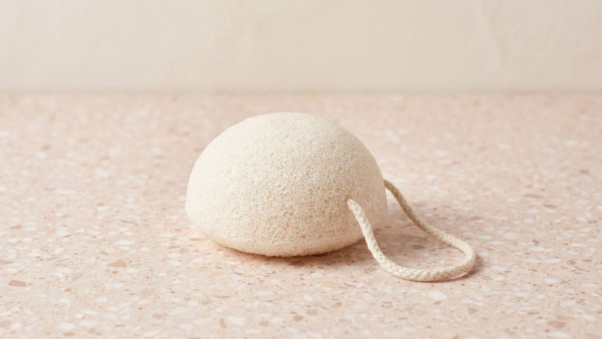 Éponge konjac ronde, beige clair et poreuse, avec sa cordelette en coton
