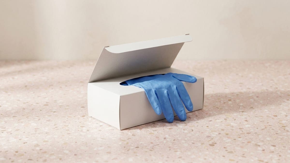 Boîte ouverte de gants en nitrile bleus, un gant sorti sur le bord