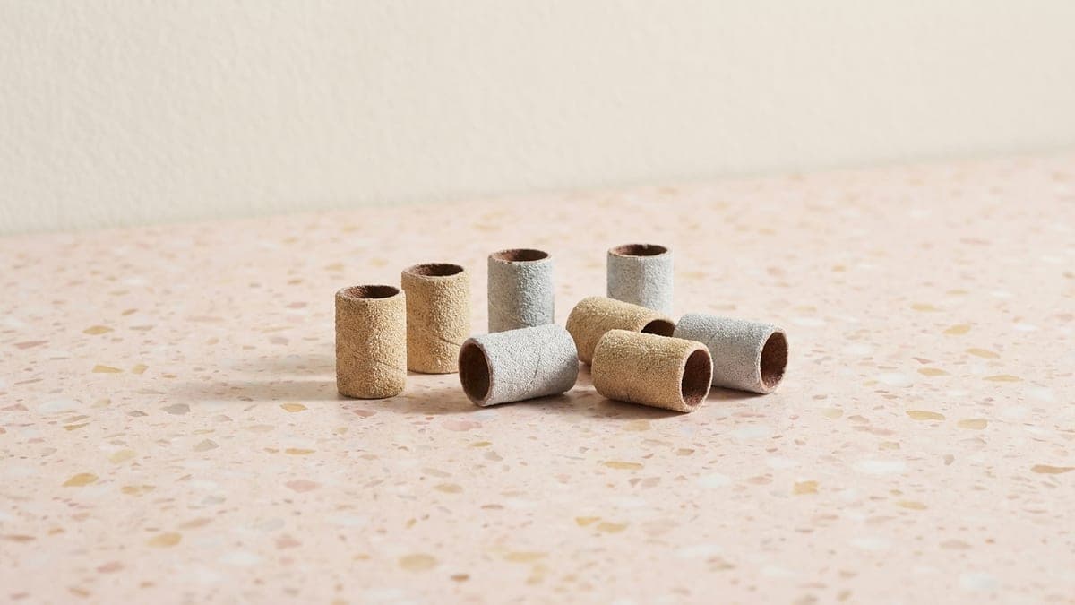 Manchons de ponçage pour ponceuse à ongles, en papier abrasif beige et gris, debout et couchés