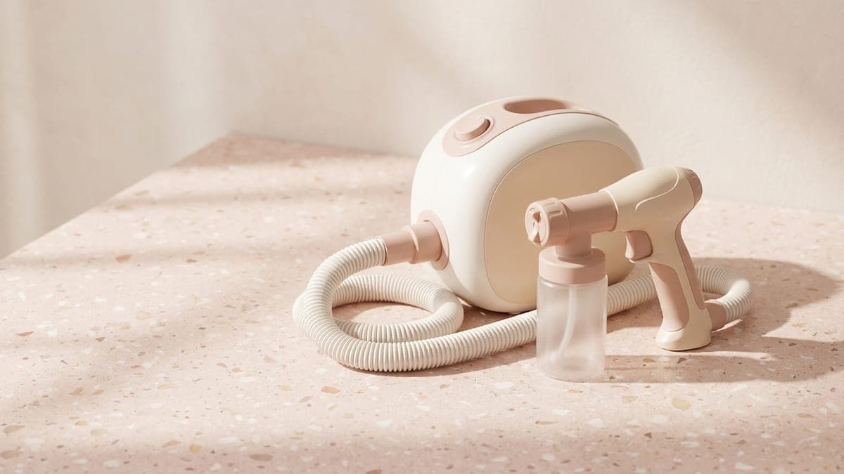 Machine de spray tan : turbine blanche et rose, tuyau souple et pistolet de pulvérisation avec son godet