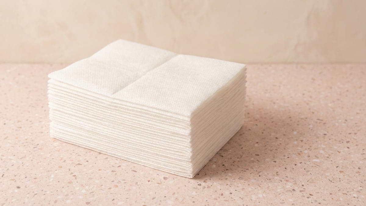 Pile de serviettes jetables blanches en non-tissé, pliées en deux