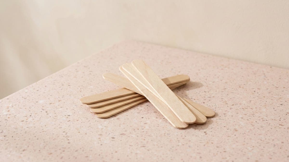 Spatules en bois clair croisées en deux petits tas