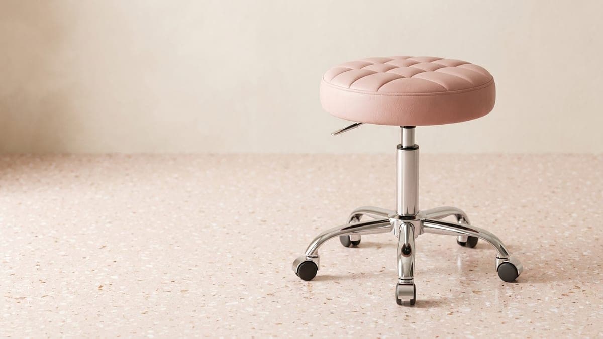 Tabouret rond à roulettes, assise en simili-cuir rose et piétement chromé